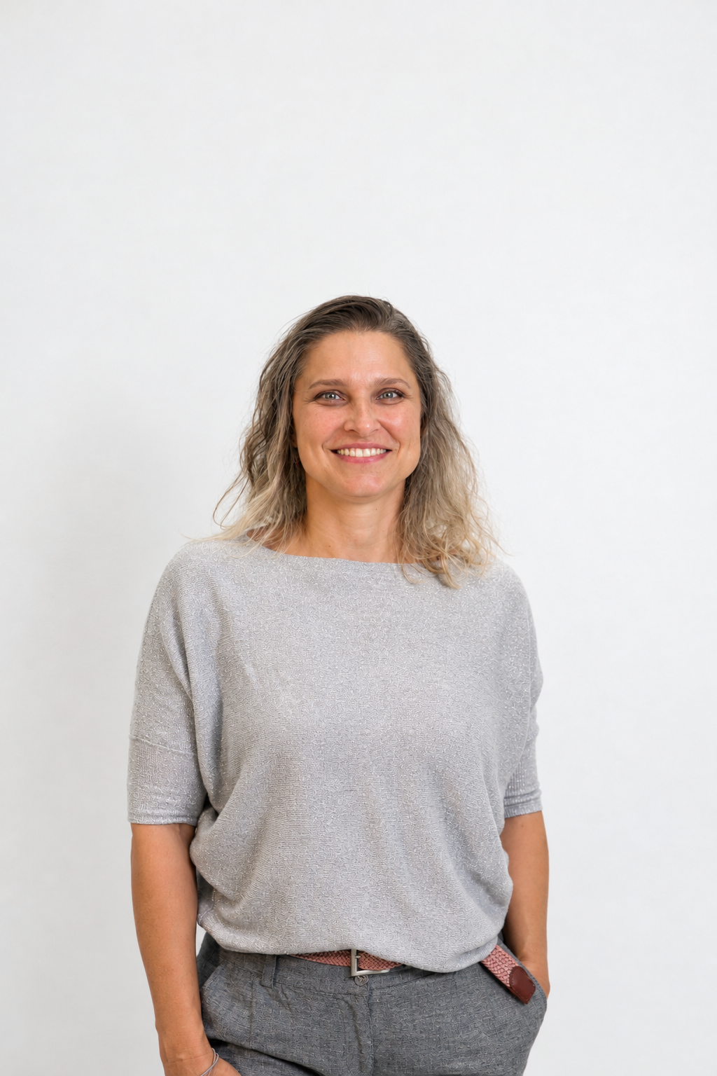 Sona, a workshop facilitator, smiling at the camera in a studio portrait with a plain light background